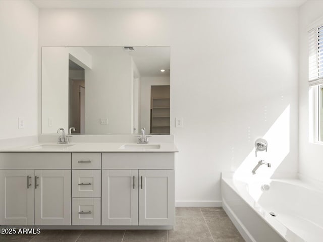 bathroom featuring double vanity, baseboards, visible vents, and a sink