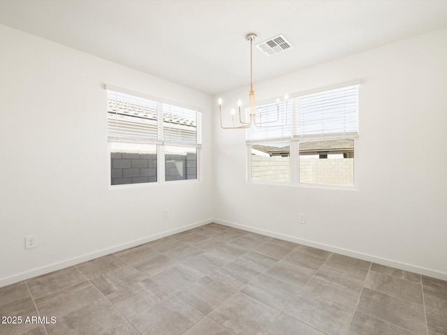 empty room featuring visible vents, baseboards, and a notable chandelier