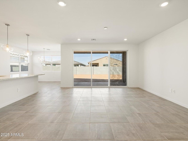 unfurnished living room with recessed lighting, baseboards, and light tile patterned floors
