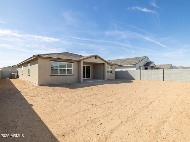 view of front facade featuring central air condition unit, a fenced backyard, and stucco siding