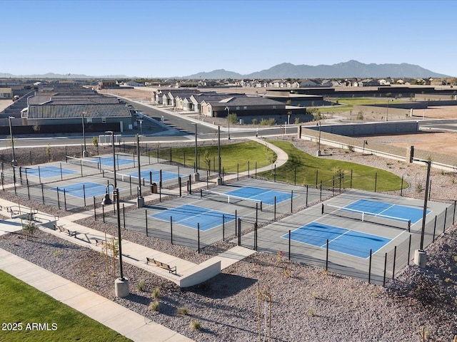 exterior space with a tennis court, a residential view, fence, and a mountain view