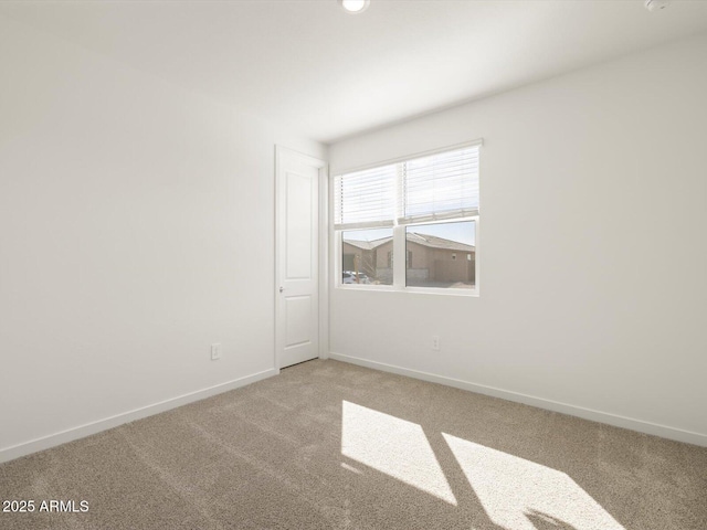 empty room with baseboards and light carpet