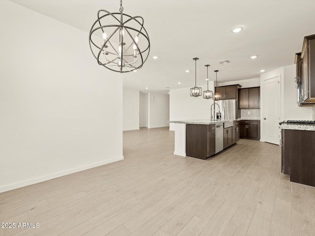 4035 S 176th Dr, Goodyear, AZ 85338 - kitchen with open floor plan, a chandelier, dark brown cabinets, stainless steel appliances, and recessed lighting