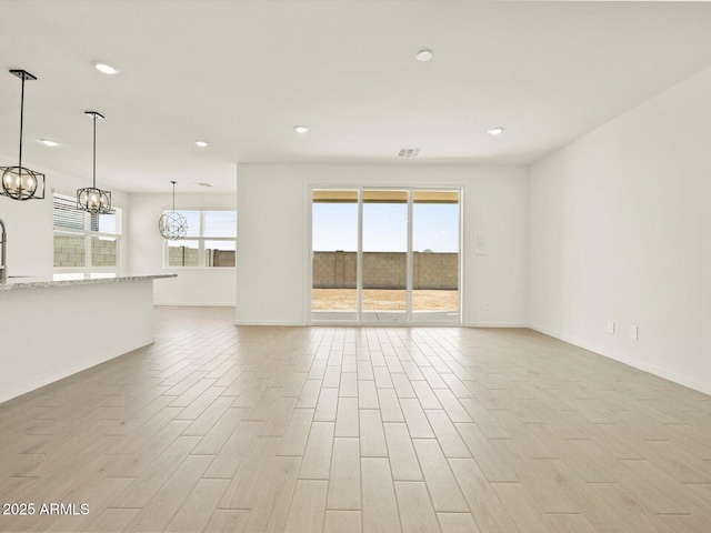 4035 S 176th Dr, Goodyear, AZ 85338 - unfurnished living room featuring a chandelier, recessed lighting, and light wood-style floors