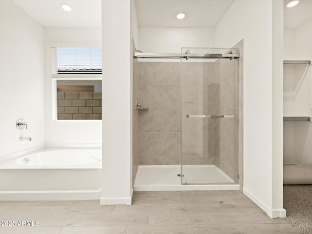 4035 S 176th Dr, Goodyear, AZ 85338 - full bath featuring a garden tub, a stall shower, recessed lighting, a walk in closet, and wood finished floors