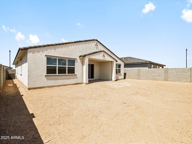 4035 S 176th Dr, Goodyear, AZ 85338 - back of property featuring a fenced backyard, stucco siding, a tiled roof, and a patio