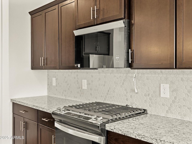 4035 S 176th Dr, Goodyear, AZ 85338 - kitchen featuring gas stove, dark brown cabinetry, decorative backsplash, and light stone counters