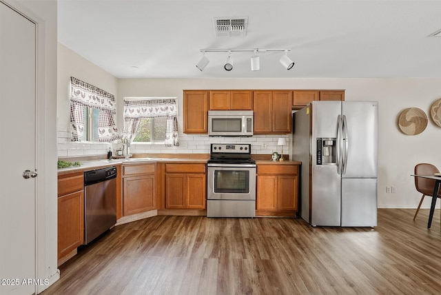 2286 E Mohave Ln, Apache Junction, AZ 85119 - kitchen with appliances with stainless steel finishes, wood finished floors, a sink, and decorative backsplash