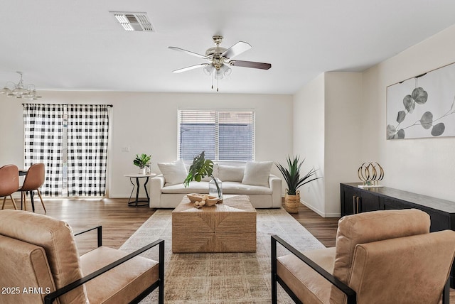 2286 E Mohave Ln, Apache Junction, AZ 85119 - living room featuring wood finished floors, a ceiling fan, baseboards, and a chandelier