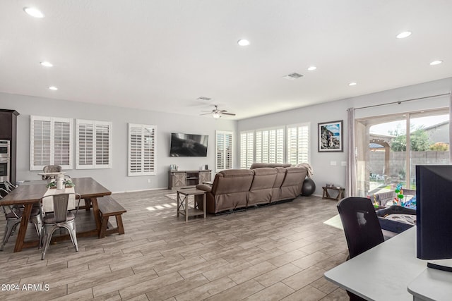 living room featuring ceiling fan and plenty of natural light