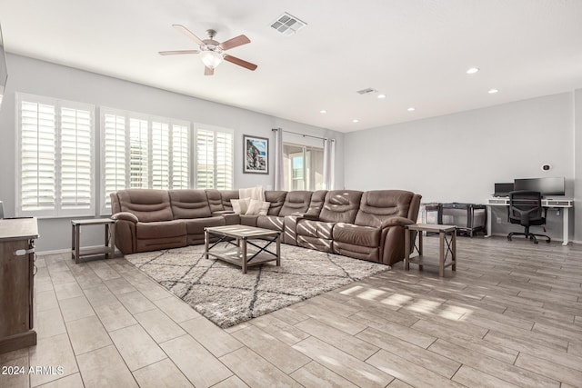 living room with light hardwood / wood-style floors and ceiling fan