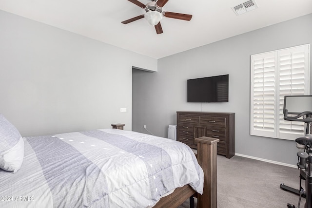 bedroom featuring multiple windows, ceiling fan, and light carpet