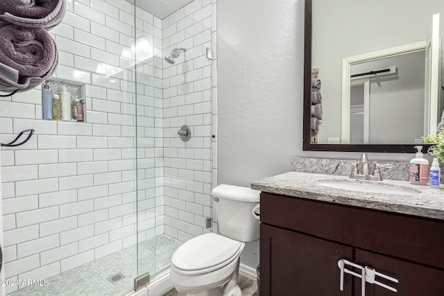 bathroom featuring vanity, an enclosed shower, and toilet