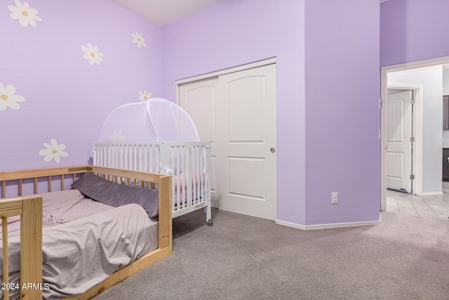 bedroom featuring light colored carpet and a closet