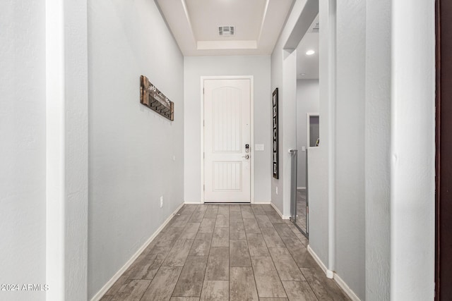 corridor featuring a tray ceiling