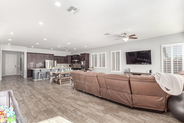 living room featuring ceiling fan and light wood-type flooring