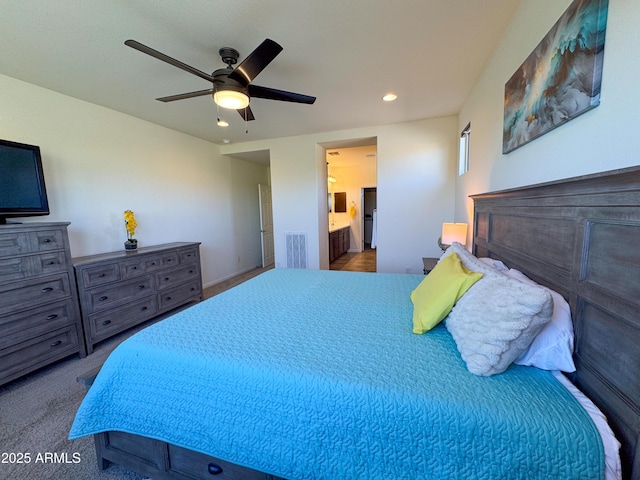 bedroom featuring ceiling fan, ensuite bathroom, and carpet flooring