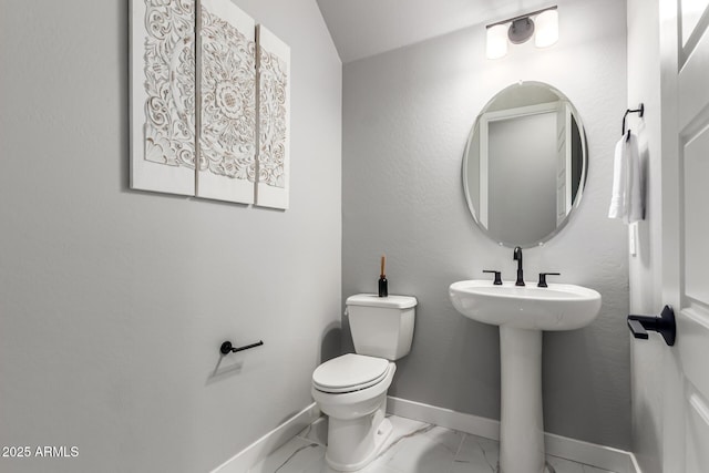 bathroom with sink, toilet, and vaulted ceiling