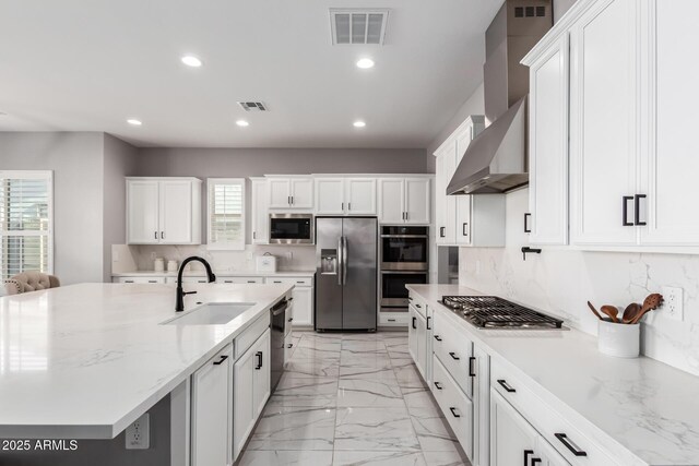 kitchen with sink, backsplash, appliances with stainless steel finishes, and wall chimney exhaust hood