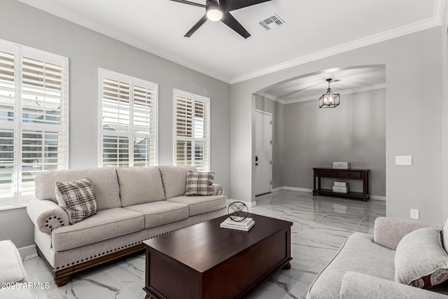 living room with ceiling fan with notable chandelier and ornamental molding