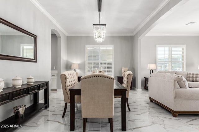 dining area featuring a chandelier and crown molding