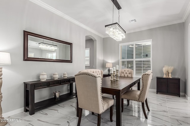 dining room with crown molding and a notable chandelier