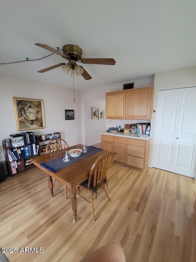 dining space featuring ceiling fan, visible vents, and light wood-style floors