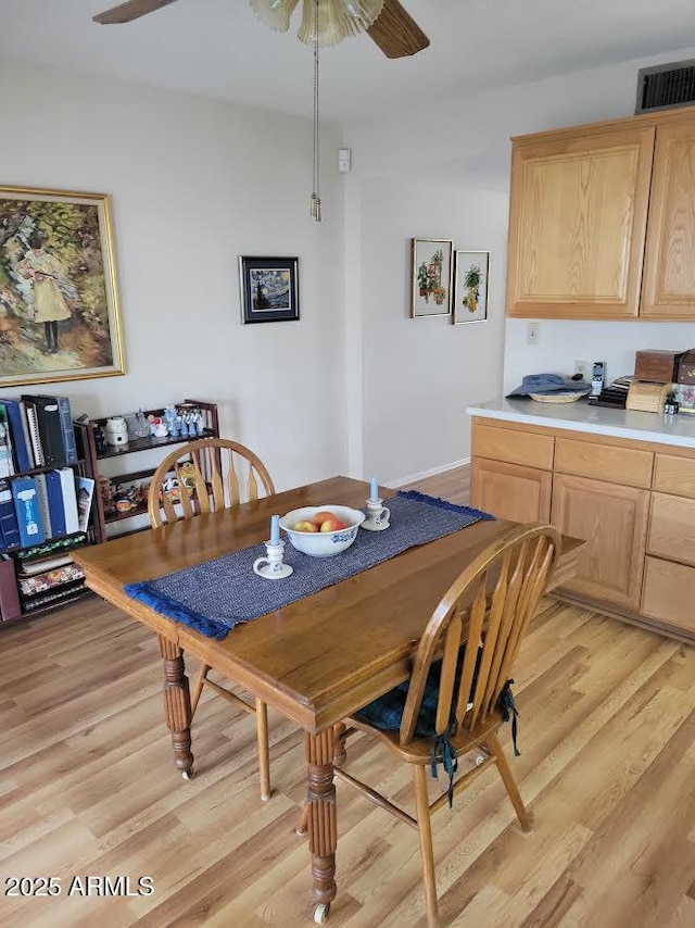 dining area featuring light wood-style floors, ceiling fan, and visible vents