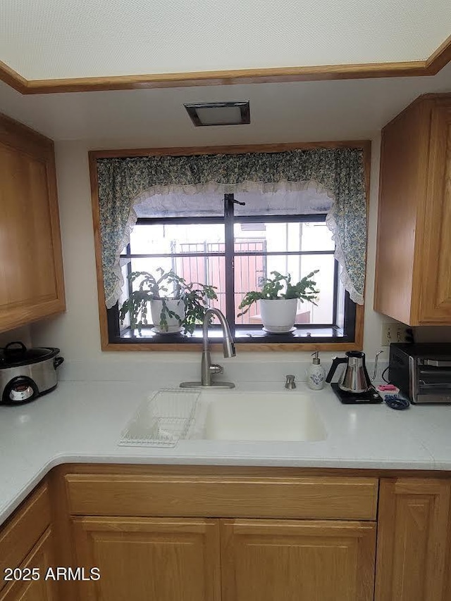 kitchen featuring light countertops, a sink, visible vents, and a toaster