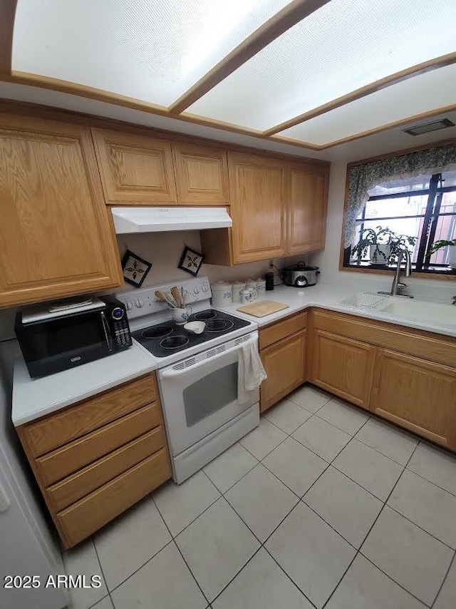 kitchen with white electric stove, under cabinet range hood, a sink, visible vents, and light countertops