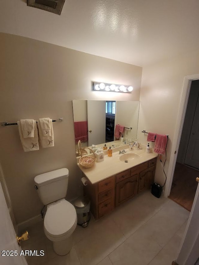 bathroom with toilet, vanity, visible vents, and tile patterned floors