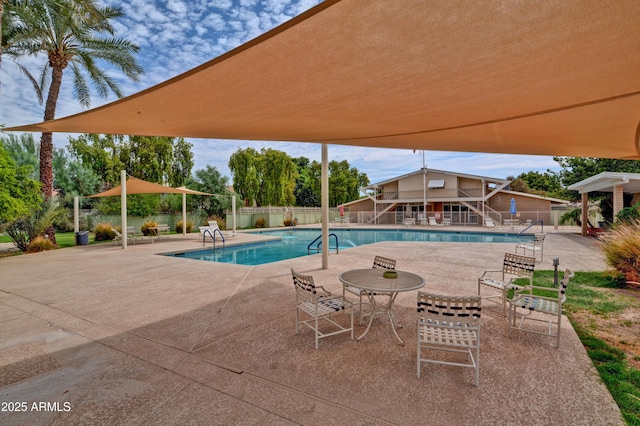 pool featuring a patio area, fence, and stairway