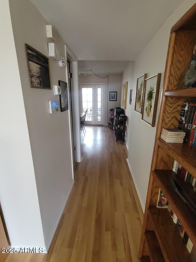 hall with light wood finished floors and baseboards