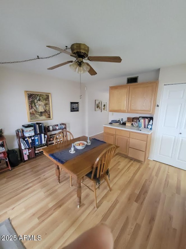 dining space featuring light wood-style floors, visible vents, and a ceiling fan