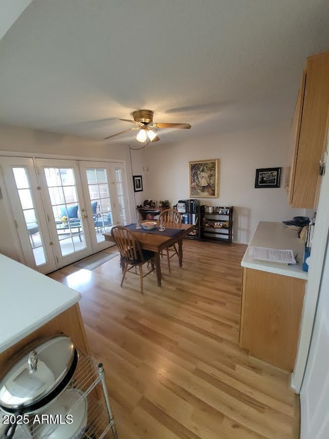 dining room featuring french doors, light wood-style flooring, and a ceiling fan