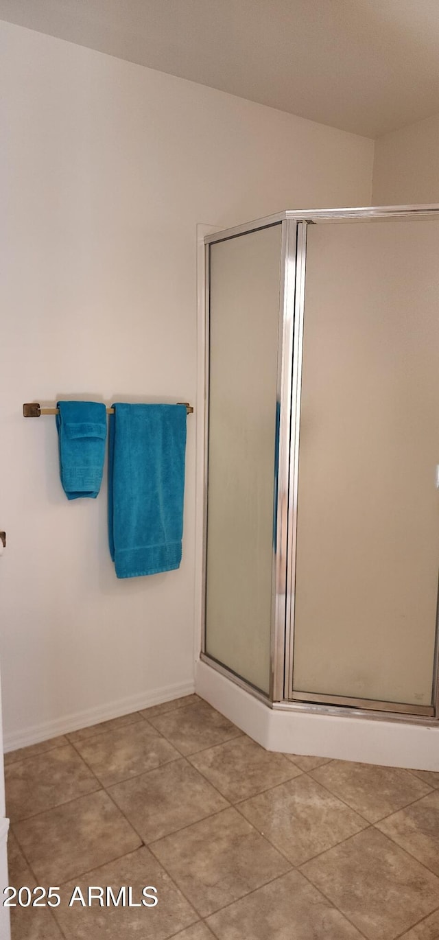 bathroom with a shower with shower door and tile patterned flooring