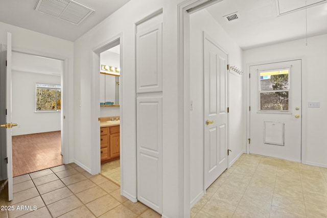 hallway featuring a wealth of natural light and light tile patterned flooring