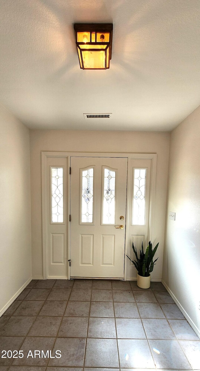 tiled foyer with a textured ceiling