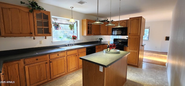 kitchen with hanging light fixtures, sink, a kitchen island, and black appliances