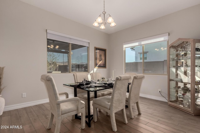 dining area with hardwood / wood-style floors and a notable chandelier