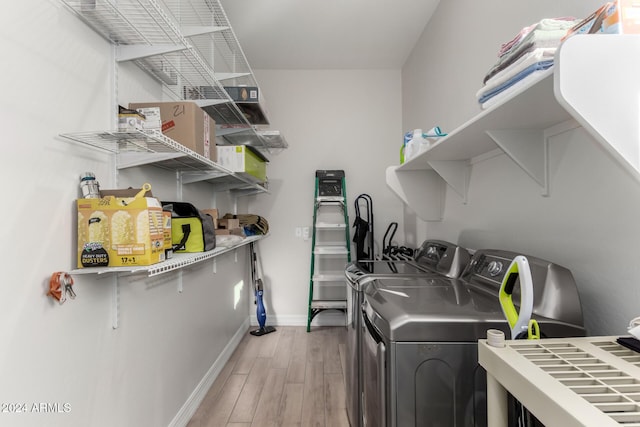 clothes washing area with hardwood / wood-style floors and washing machine and clothes dryer