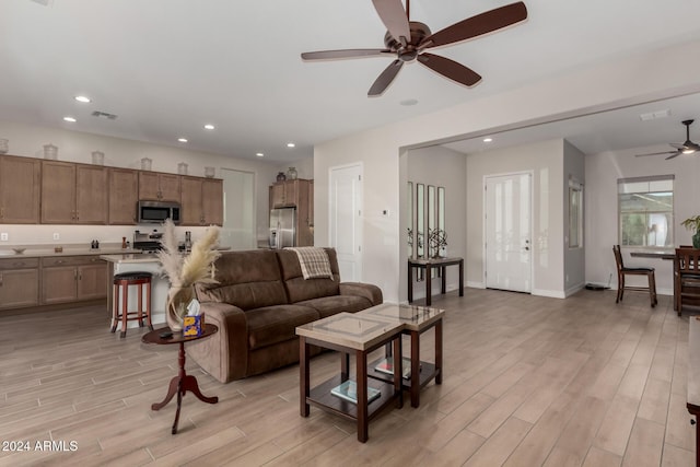 living room with ceiling fan and light wood-type flooring