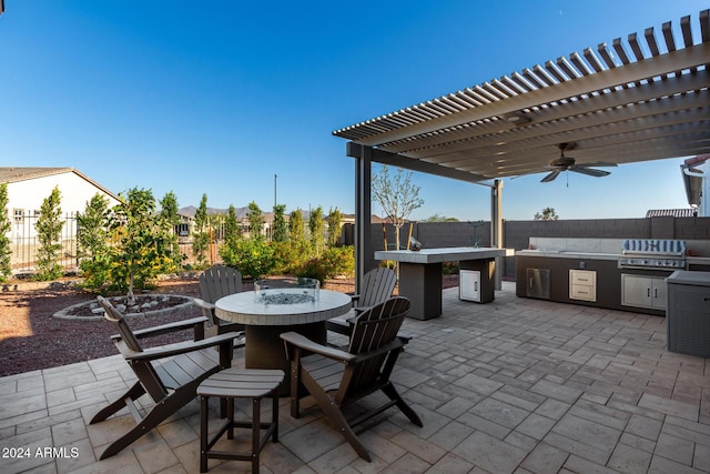 view of patio / terrace with exterior kitchen, area for grilling, a pergola, and ceiling fan