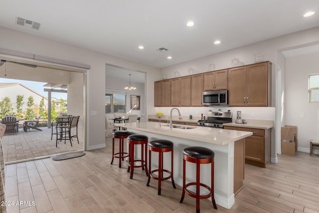 kitchen featuring plenty of natural light, sink, stainless steel appliances, and light hardwood / wood-style flooring