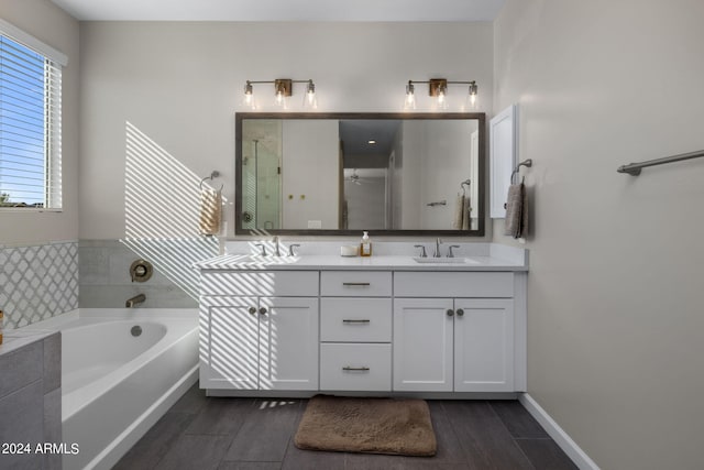 bathroom with a tub and dual bowl vanity