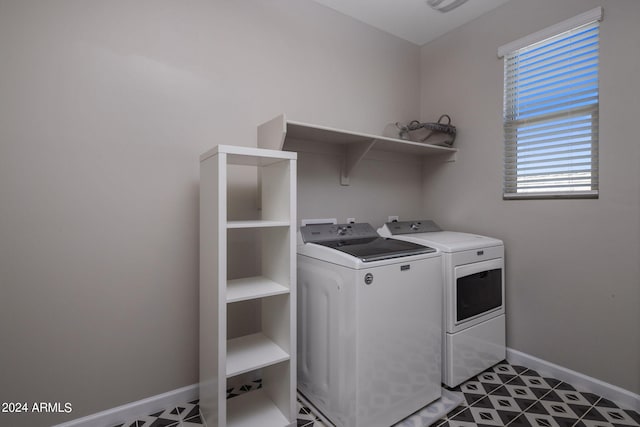 laundry area with dark tile patterned flooring and washing machine and clothes dryer