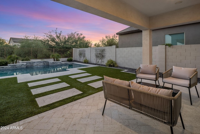 pool at dusk featuring a patio and an outdoor hangout area