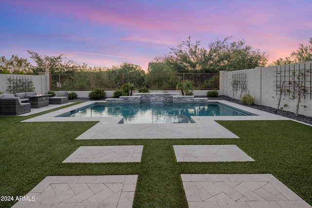 pool at dusk with a patio area, a yard, and outdoor lounge area