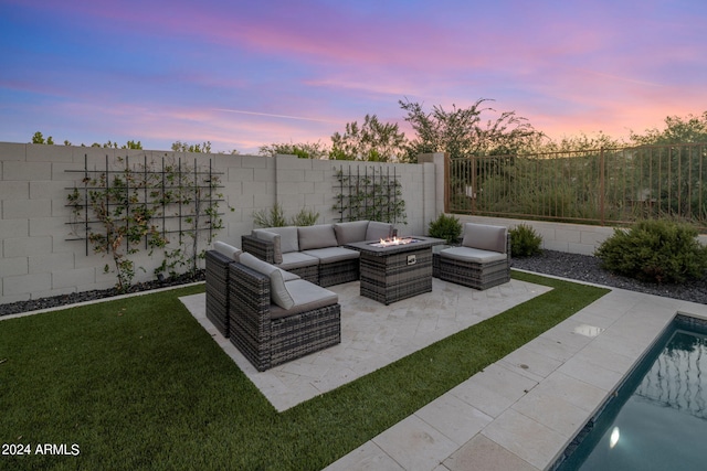 patio terrace at dusk featuring a fenced in pool, a yard, and an outdoor hangout area