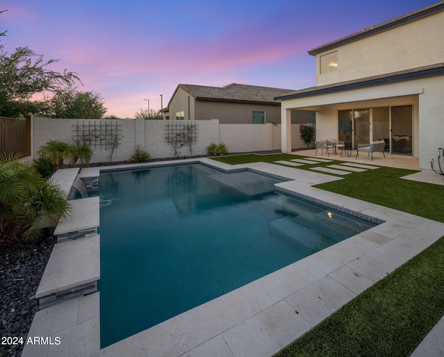 pool at dusk with a patio